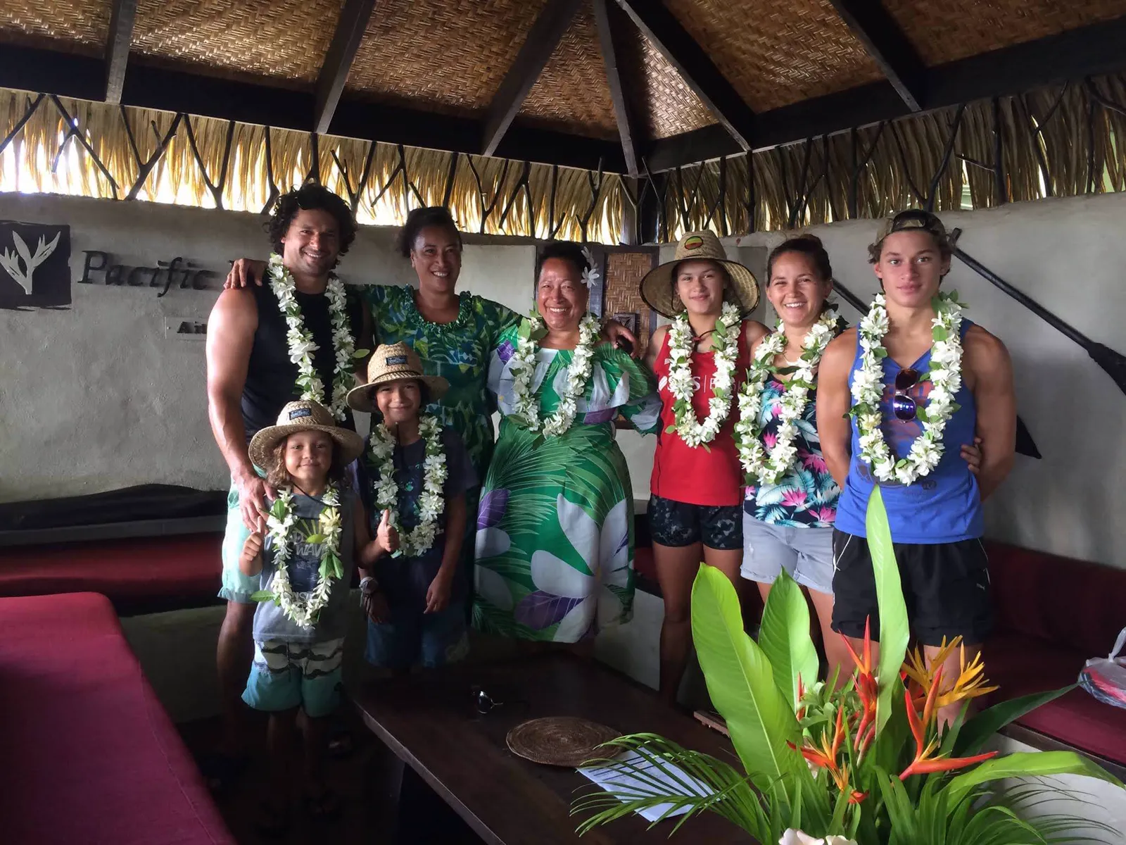 Vern with his whānau in Aitutaki, three generations wearing white flower ei, his mum smiling in the middle